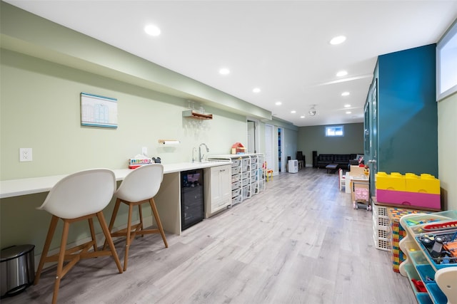 1200 Roger Rd, North Bellmore, NY 11710 - indoor wet bar with beverage cooler, light wood-style floors, and recessed lighting