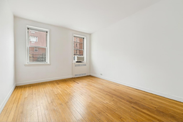 63109 Saunders St Unit 3A, Rego Park, NY 11374 - spare room with radiator, light wood-style floors, healthy amount of natural light, and cooling unit