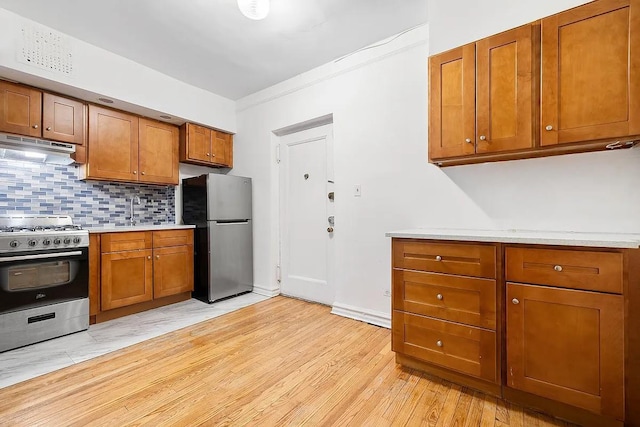 63109 Saunders St Unit 3A, Rego Park, NY 11374 - kitchen featuring stainless steel appliances, under cabinet range hood, light countertops, and decorative backsplash