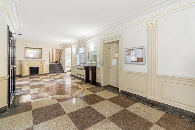 63109 Saunders St Unit 3A, Rego Park, NY 11374 - entryway with ornamental molding, a fireplace, a decorative wall, arched walkways, and a wainscoted wall
