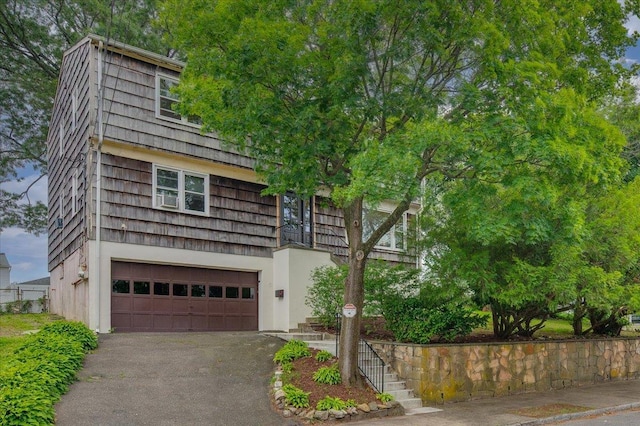 32 Brady Ave, New Rochelle, NY 10805 - view of front of house with an attached garage, asphalt driveway, stairway, and stucco siding