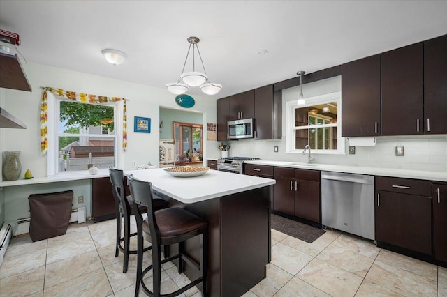 32 Brady Ave, New Rochelle, NY 10805 - kitchen featuring stainless steel appliances, tasteful backsplash, light countertops, dark brown cabinetry, and a baseboard heating unit