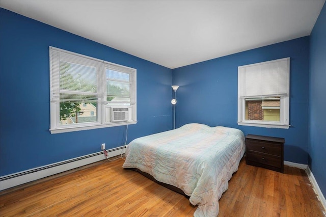 32 Brady Ave, New Rochelle, NY 10805 - bedroom with a baseboard radiator, wood finished floors, and cooling unit