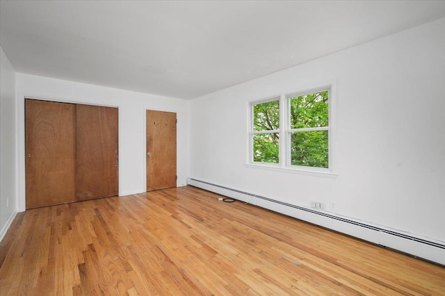 32 Brady Ave, New Rochelle, NY 10805 - unfurnished bedroom with a baseboard heating unit, light wood-style flooring, and a closet