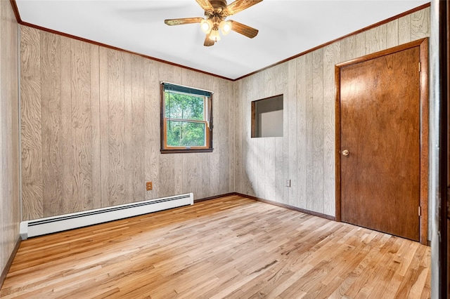 408 Bull Rd, Rock Tavern, NY 12575 - empty room with a baseboard radiator, wood finished floors, a ceiling fan, ornamental molding, and wood walls
