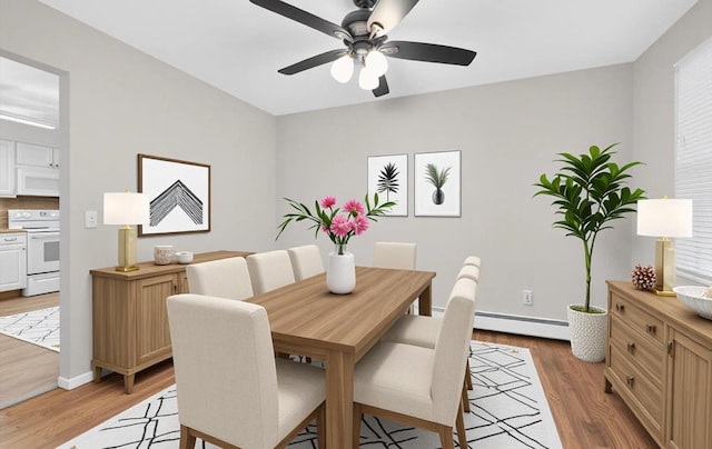 1152 N Country Rd, Stony Brook, NY 11790 - dining area featuring a baseboard radiator, light wood-style flooring, and a ceiling fan