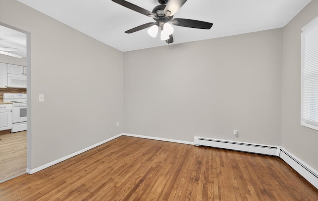 1152 N Country Rd, Stony Brook, NY 11790 - spare room featuring a ceiling fan, light wood finished floors, plenty of natural light, and a baseboard heating unit