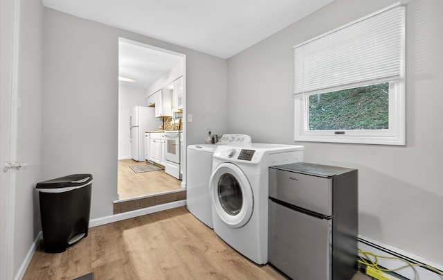 1152 N Country Rd, Stony Brook, NY 11790 - laundry room with baseboard heating, washing machine and clothes dryer, and light wood-type flooring