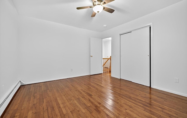 1152 N Country Rd, Stony Brook, NY 11790 - unfurnished bedroom with a baseboard radiator, hardwood / wood-style flooring, a ceiling fan, and a closet