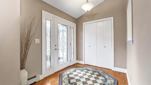 12 Hasting Dr, Stony Brook, NY 11790 - entrance foyer featuring baseboard heating, healthy amount of natural light, wood finished floors, and vaulted ceiling
