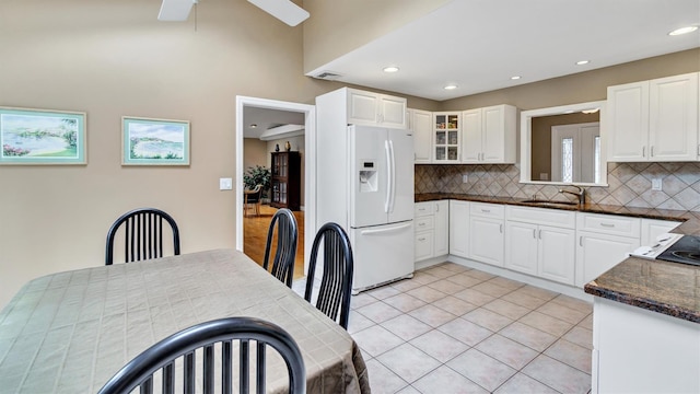 12 Hasting Dr, Stony Brook, NY 11790 - kitchen with white fridge with ice dispenser, backsplash, white cabinetry, ceiling fan, and light tile patterned flooring