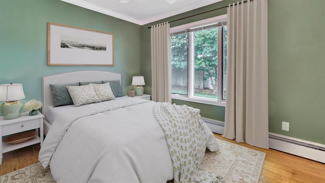 12 Hasting Dr, Stony Brook, NY 11790 - bedroom featuring wood finished floors, ornamental molding, and a baseboard heating unit