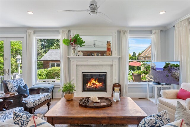12 Terry Dr, Shelter Island, NY 11964 - living area with ceiling fan, a glass covered fireplace, wood finished floors, recessed lighting, and ornamental molding