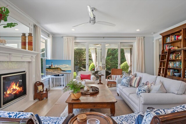 12 Terry Dr, Shelter Island, NY 11964 - living area with a tile fireplace, ceiling fan, plenty of natural light, wood finished floors, and ornamental molding