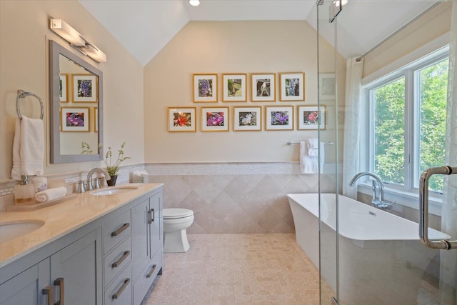 12 Terry Dr, Shelter Island, NY 11964 - bathroom with double vanity, vaulted ceiling, a freestanding tub, tile patterned flooring, and tile walls