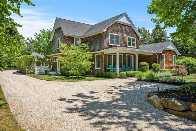 12 Terry Dr, Shelter Island, NY 11964 - view of front facade with a porch, gravel driveway, and a shingled roof