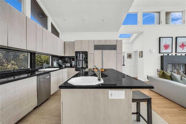 146 Ocean Walk, Fire Island Pines, NY 11782 - kitchen featuring stainless steel dishwasher, paneled built in refrigerator, a towering ceiling, dark countertops, and a kitchen bar