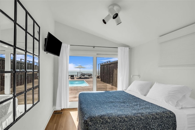 146 Ocean Walk, Fire Island Pines, NY 11782 - bedroom with access to outside, vaulted ceiling, and wood finished floors