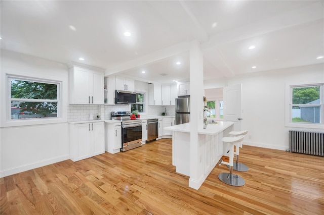 17 Pinetree Dr, Shirley, NY 11967 - kitchen with stainless steel appliances, radiator heating unit, light wood-type flooring, light countertops, and recessed lighting
