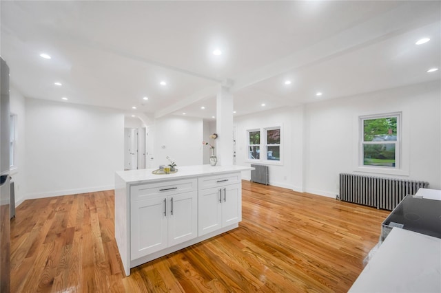 17 Pinetree Dr, Shirley, NY 11967 - kitchen with radiator heating unit, white cabinets, light wood-style floors, recessed lighting, and light countertops