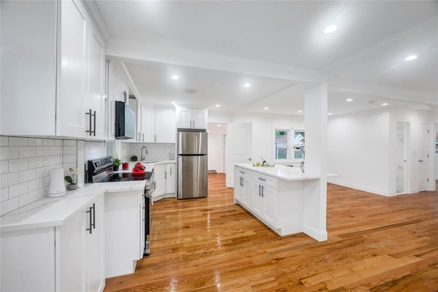 17 Pinetree Dr, Shirley, NY 11967 - kitchen with appliances with stainless steel finishes, white cabinets, backsplash, light wood-type flooring, and recessed lighting
