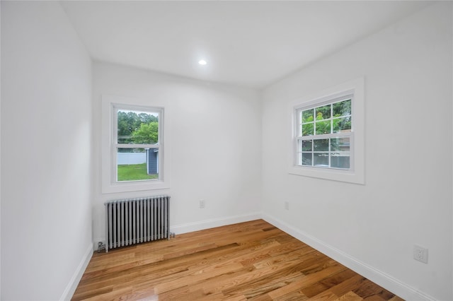 17 Pinetree Dr, Shirley, NY 11967 - spare room featuring radiator, light wood-type flooring, and recessed lighting