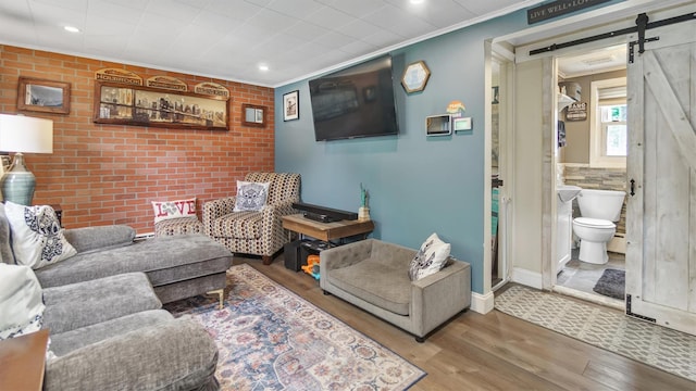 27 Lidge Dr, Farmingville, NY 11738 - living area with a barn door, wood finished floors, ornamental molding, and recessed lighting