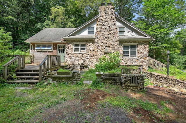 1973 State Route 17k, Montgomery, NY 12549 - view of front of house with a chimney, a wooden deck, stone siding, and stairway