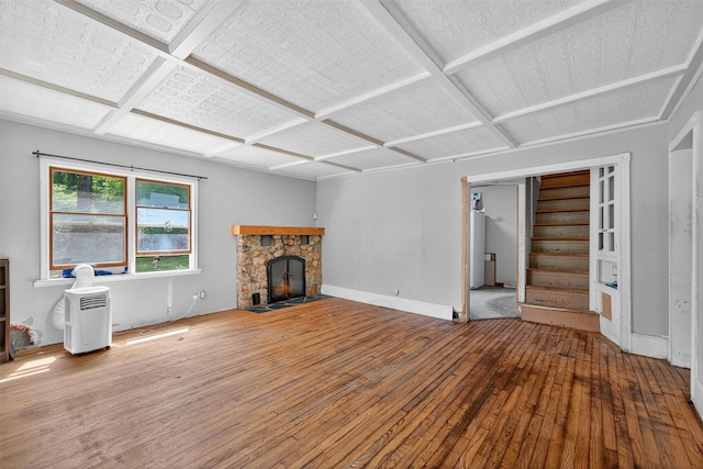 1973 State Route 17k, Montgomery, NY 12549 - unfurnished living room featuring hardwood / wood-style flooring, a stone fireplace, and stairs