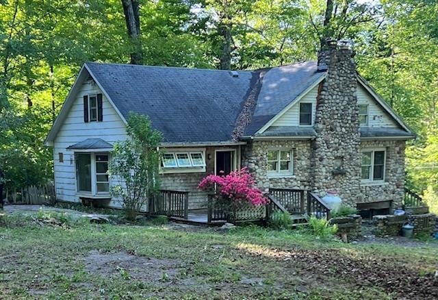 1973 State Route 17k, Montgomery, NY 12549 - view of front facade featuring a chimney, stone siding, a deck, and view of wooded area