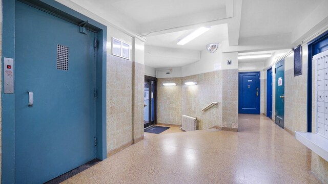 1610 Metropolitan Ave Unit 6H, Bronx, NY 10462 - corridor with speckle patterned floor, radiator heating unit, and tile walls