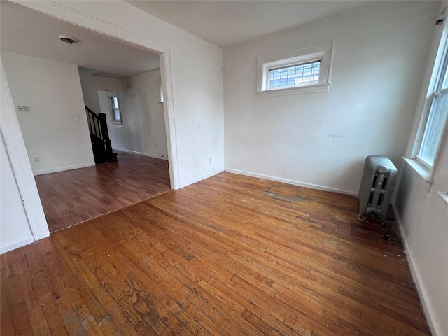 11617 141st St, Jamaica, NY 11436 - empty room featuring wood-type flooring, stairway, and radiator heating unit