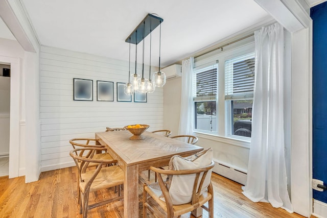 271 Foster Ave, Sayville, NY 11782 - dining space with a baseboard radiator, an AC wall unit, light wood-style flooring, wood walls, and a chandelier