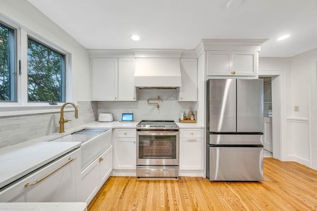 271 Foster Ave, Sayville, NY 11782 - kitchen featuring stainless steel appliances, custom range hood, light countertops, white cabinets, and tasteful backsplash