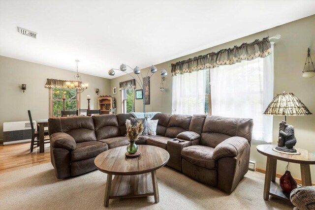 61 Travis Blvd, Catskill, NY 12414 - living room with a chandelier, light carpet, and a baseboard heating unit