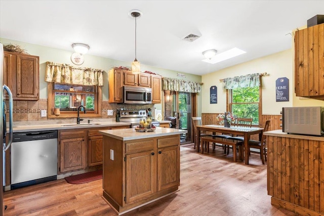 61 Travis Blvd, Catskill, NY 12414 - kitchen featuring appliances with stainless steel finishes, light countertops, wainscoting, a skylight, and light wood-style flooring