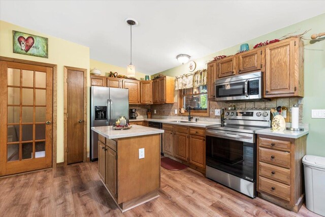 61 Travis Blvd, Catskill, NY 12414 - kitchen with appliances with stainless steel finishes, light countertops, decorative backsplash, a center island, and wood finished floors