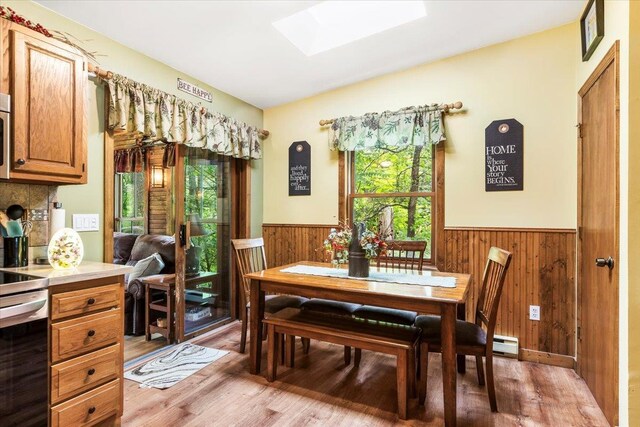 61 Travis Blvd, Catskill, NY 12414 - dining room with wainscoting, light wood-style flooring, healthy amount of natural light, wooden walls, and a skylight