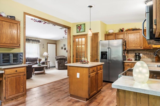 61 Travis Blvd, Catskill, NY 12414 - kitchen with appliances with stainless steel finishes, brown cabinetry, a center island, tasteful backsplash, and light countertops