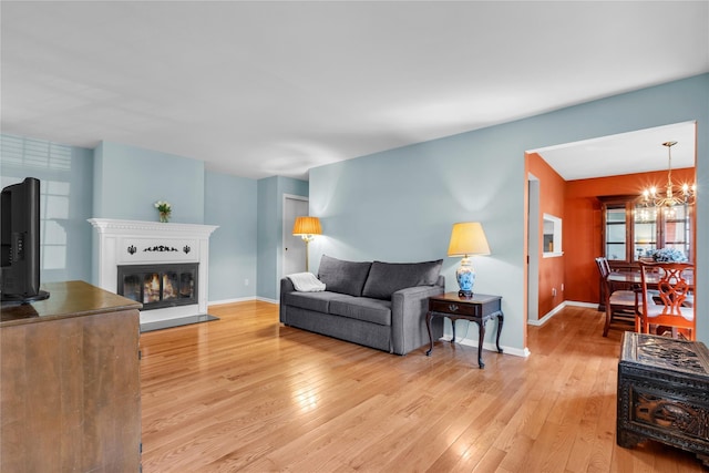 9 Foxwood Dr Unit 4, Pleasantville, NY 10570 - living room with light wood-type flooring, a chandelier, and a glass covered fireplace