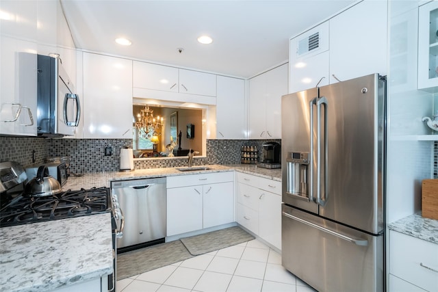 17 Jared Dr, White Plains, NY 10605 - kitchen with stainless steel appliances, white cabinets, decorative backsplash, light tile patterned flooring, and recessed lighting