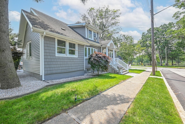 36 W Saint Marks Pl, Valley Stream, NY 11580 - view of home's exterior featuring a shingled roof and a lawn
