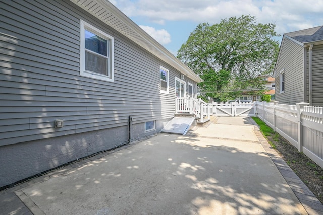 36 W Saint Marks Pl, Valley Stream, NY 11580 - view of property exterior with a patio area, a fenced backyard, and a gate