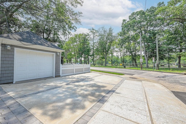 36 W Saint Marks Pl, Valley Stream, NY 11580 - detached garage with driveway and view of wooded area