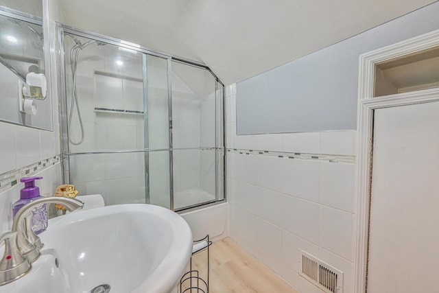 36 W Saint Marks Pl, Valley Stream, NY 11580 - full bath featuring tile walls, shower / bath combination with glass door, and wood finished floors