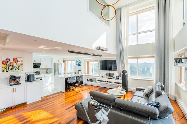 4318 Main St Unit 12A, Flushing, NY 11355 - living area featuring light wood-type flooring and a towering ceiling