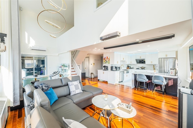 4318 Main St Unit 12A, Flushing, NY 11355 - living room featuring a towering ceiling, stairway, and light wood-style flooring
