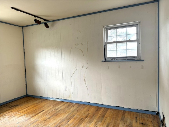 22 Kennedy Dr, Centereach, NY 11720 - empty room with hardwood / wood-style floors and wooden walls