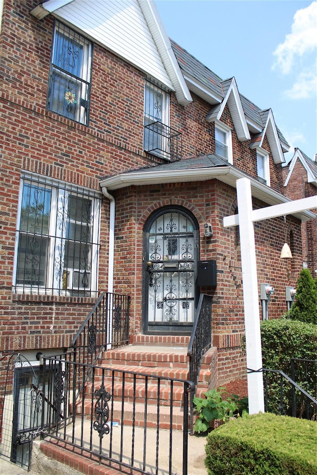 30-12 84th St, East Elmhurst, NY 11370 - view of exterior entry with brick siding and a balcony