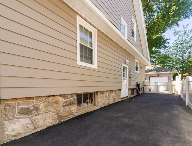 58 Hillside Ave, New Rochelle, NY 10801 - view of side of home featuring a garage, an outbuilding, a gate, and asphalt driveway